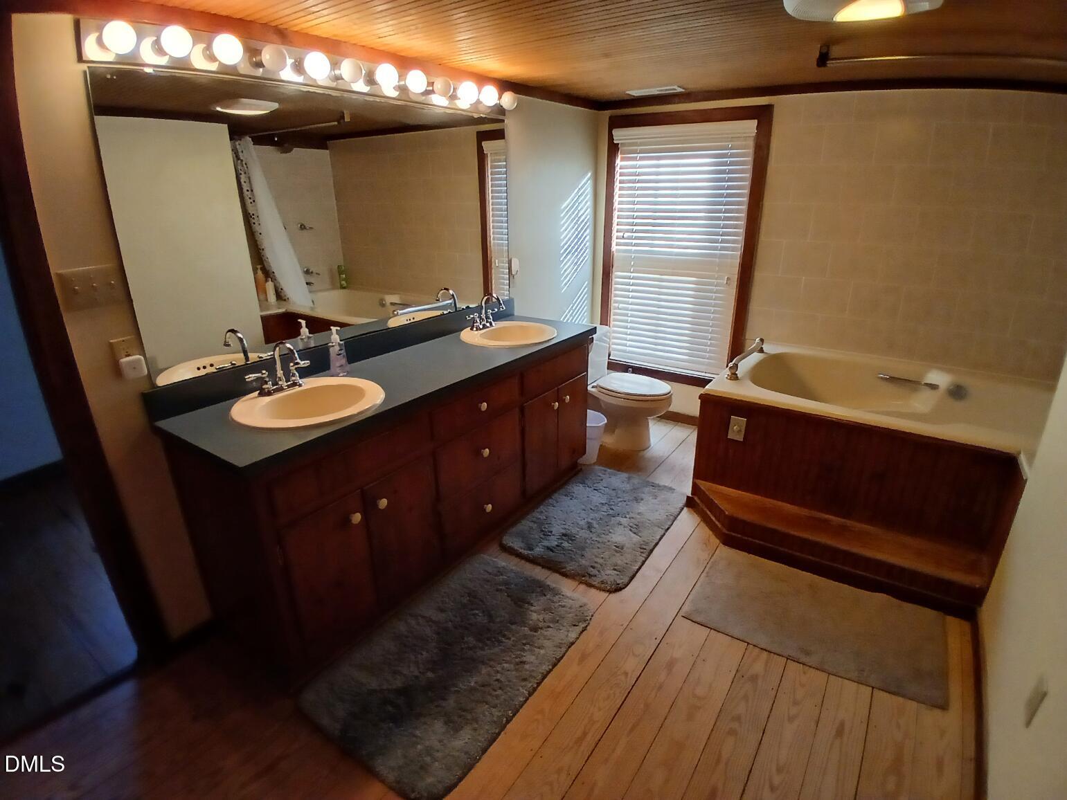 1920 Kelly Road Apex, NC 27502 - Photo 39 of 44 a bathroom with a double vanity sink a toilet and a mirror