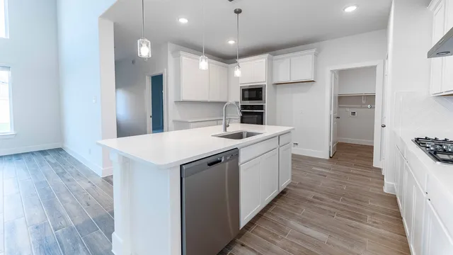 a kitchen with a sink refrigerator and cabinets