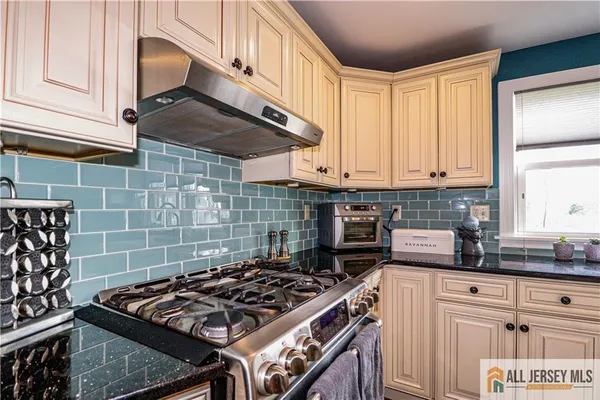 a kitchen with granite countertop a stove sink and cabinets