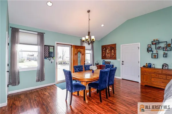a dining room with furniture a chandelier and wooden floor