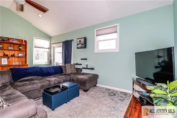 a living room with furniture a flat screen tv and a window