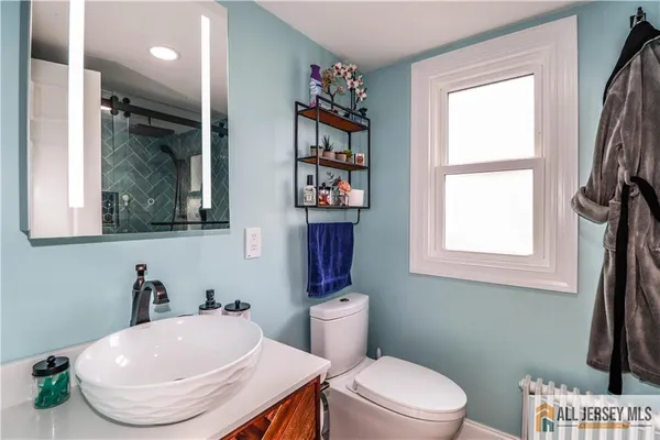 a bathroom with a toilet a sink and a window