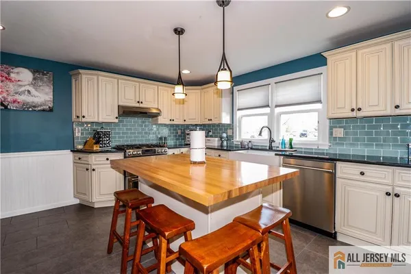 a kitchen with stainless steel appliances granite countertop a sink a stove and a center island