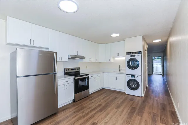 a kitchen with a refrigerator a stove top oven and wooden floor