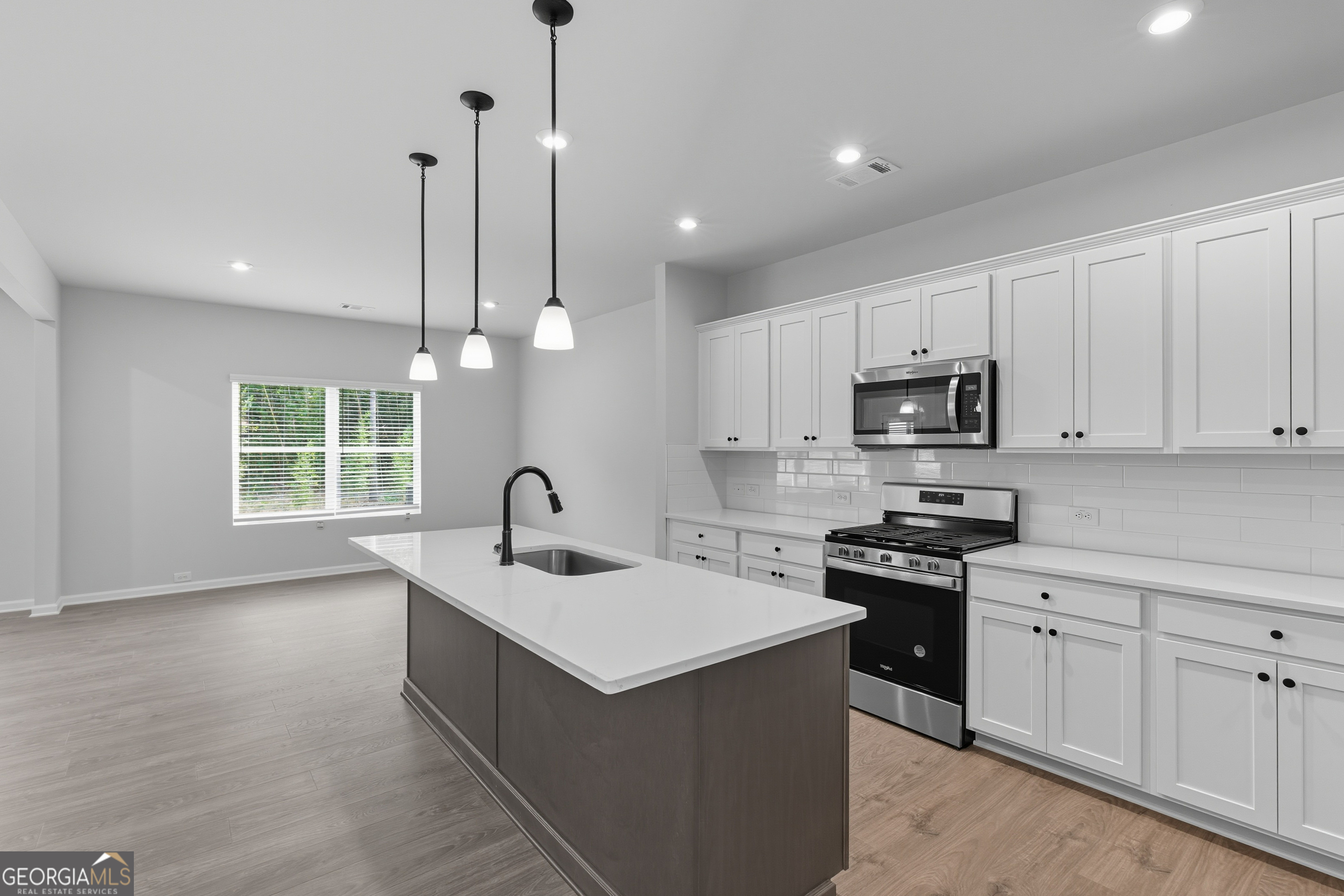 103 Everest Court Dallas, GA 30132 - Photo 15 of 35 a kitchen with stainless steel appliances granite countertop a sink a stove a microwave a center island and a window