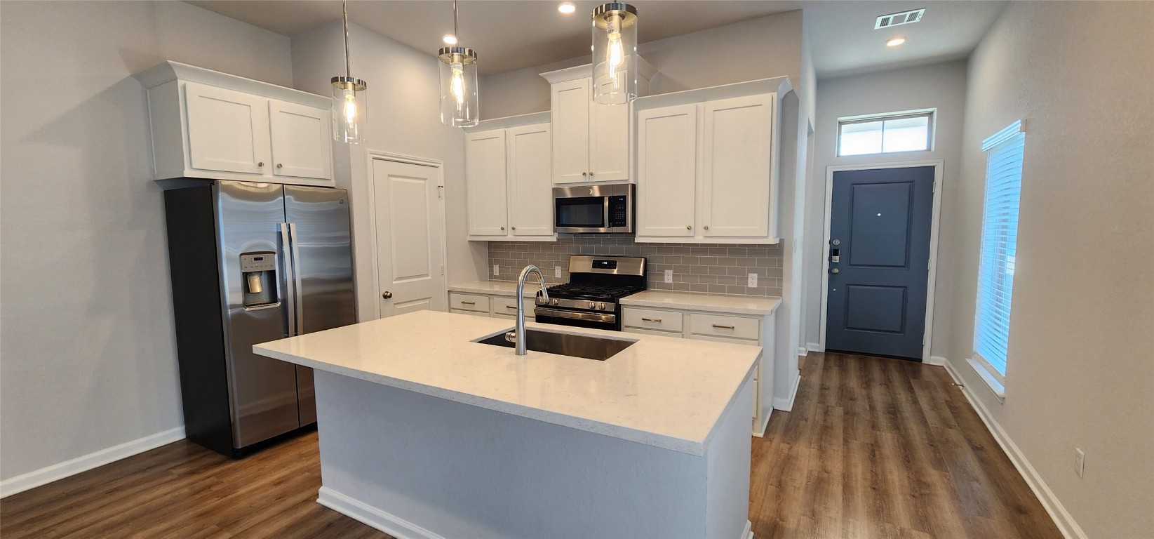 212 Los Olives Lane Georgetown, TX 78628 - Photo 11 of 35 a kitchen with a refrigerator a stove top oven and wooden floor