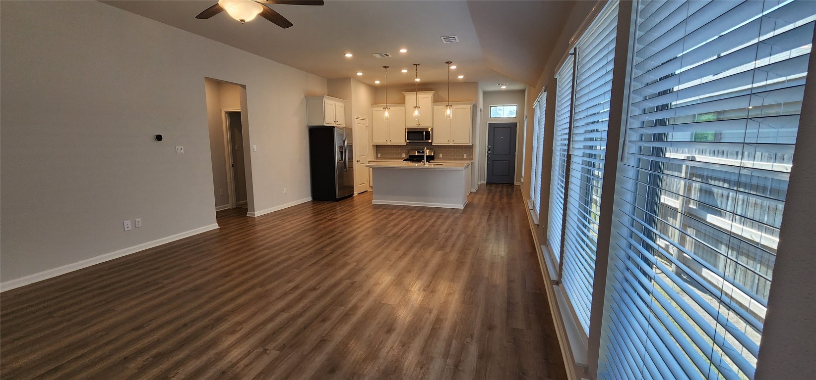 212 Los Olives Lane Georgetown, TX 78628 - Photo 14 of 35 a view of a hallway with wooden floor and a kitchen