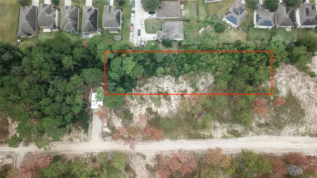 an aerial view of residential houses with outdoor space and trees