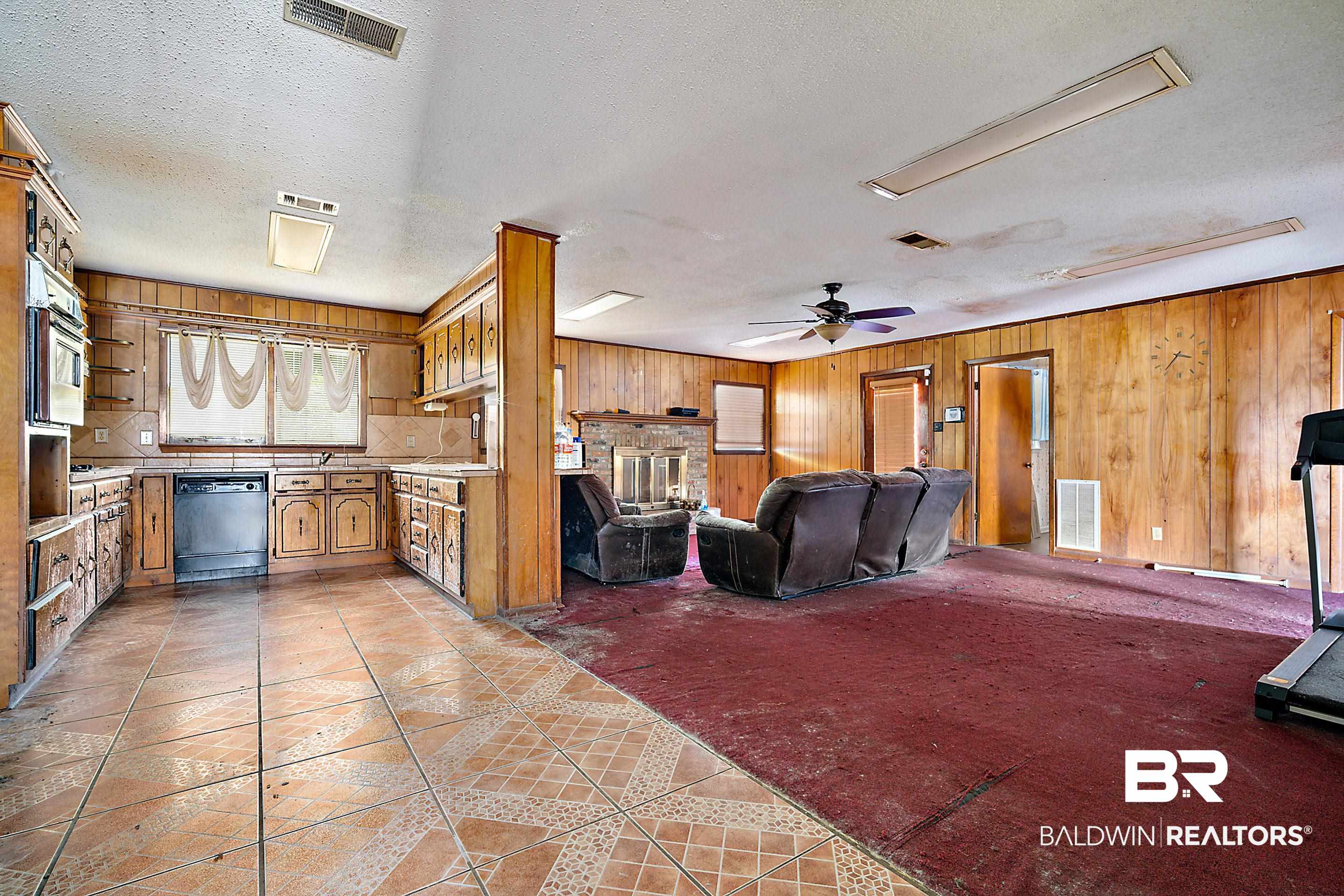 576 Markham Drive Mobile, AL 36609 - Photo 5 of 18 Living room featuring wooden walls, light tile patterned flooring, a textured ceiling, attic access, and ceiling fan