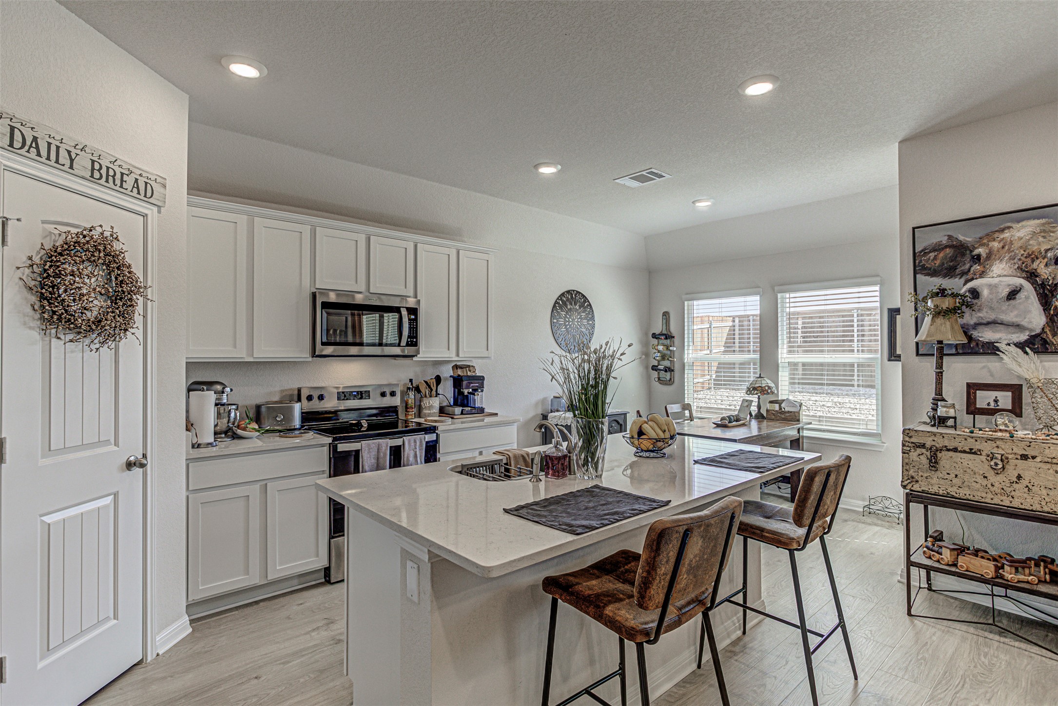 309 Lone Cedar Road Marble Falls, TX 78654 - Photo 14 of 35 Kitchen featuring white cabinetry, stainless steel appliances, a kitchen island with sink, a kitchen breakfast bar, and light stone countertops