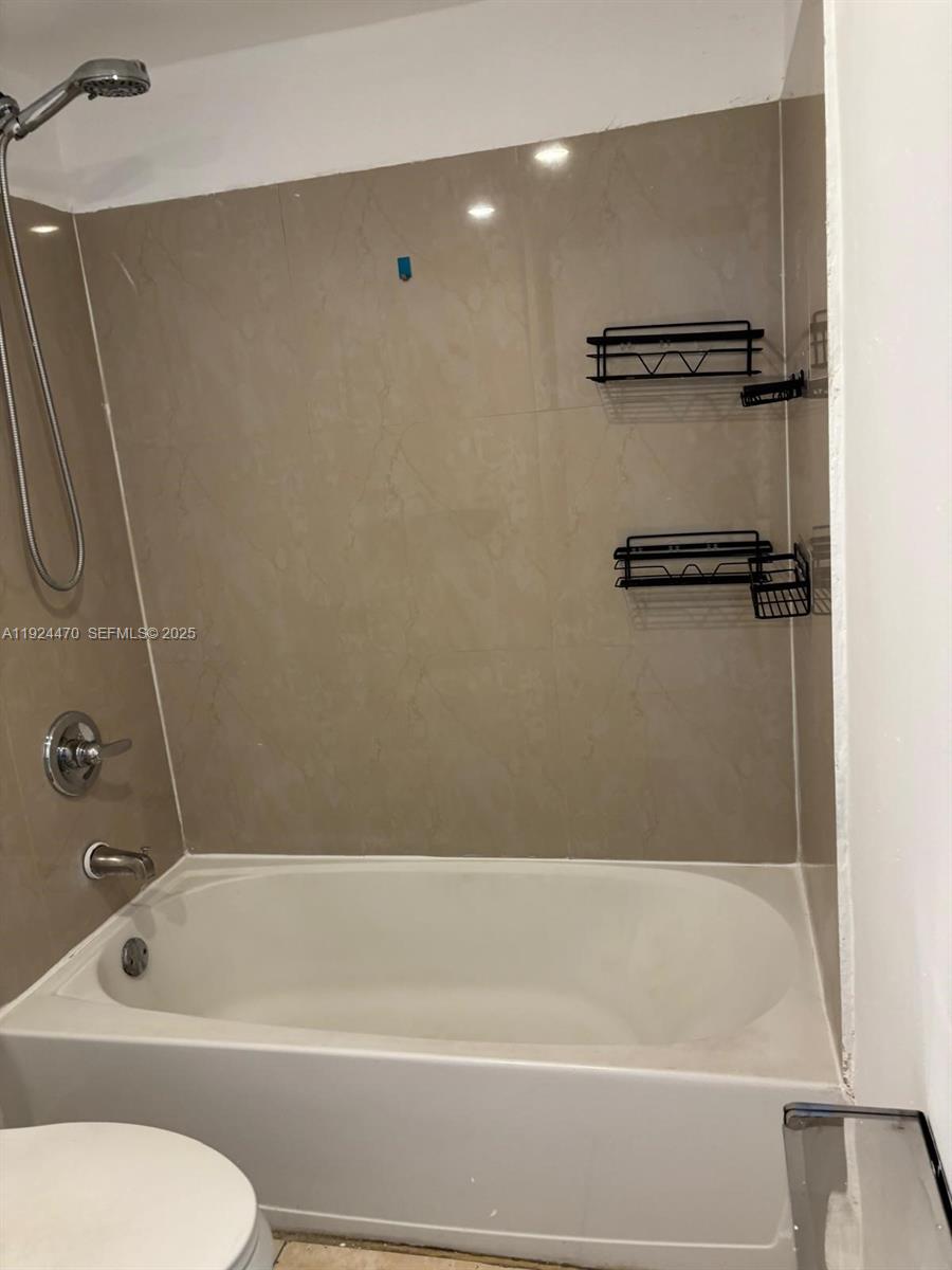 6045 Northwest 186th Street, Unit 123 Hialeah, FL 33015 - Photo 6 of 9 a bathroom with a shower and a toilet