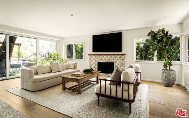 a living room with furniture a flat screen tv and a fireplace