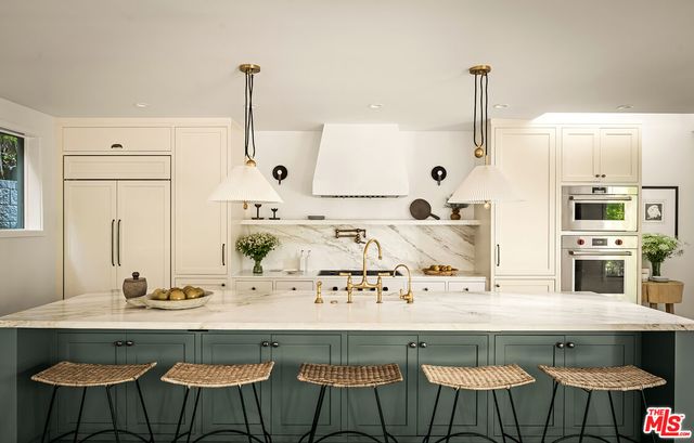 a kitchen with stainless steel appliances a sink and white cabinets