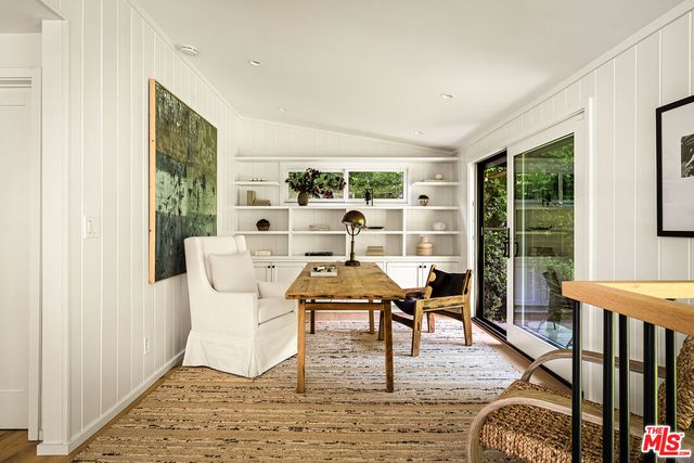 a living room with furniture floor to ceiling window and wooden floor