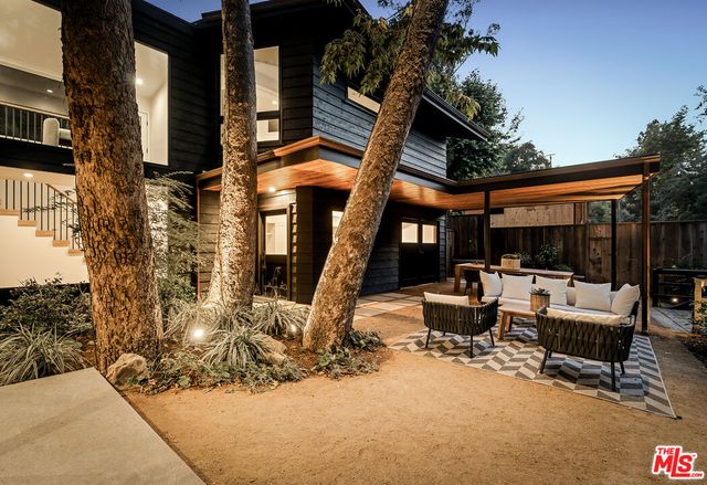 a view of backyard with outdoor seating and plants