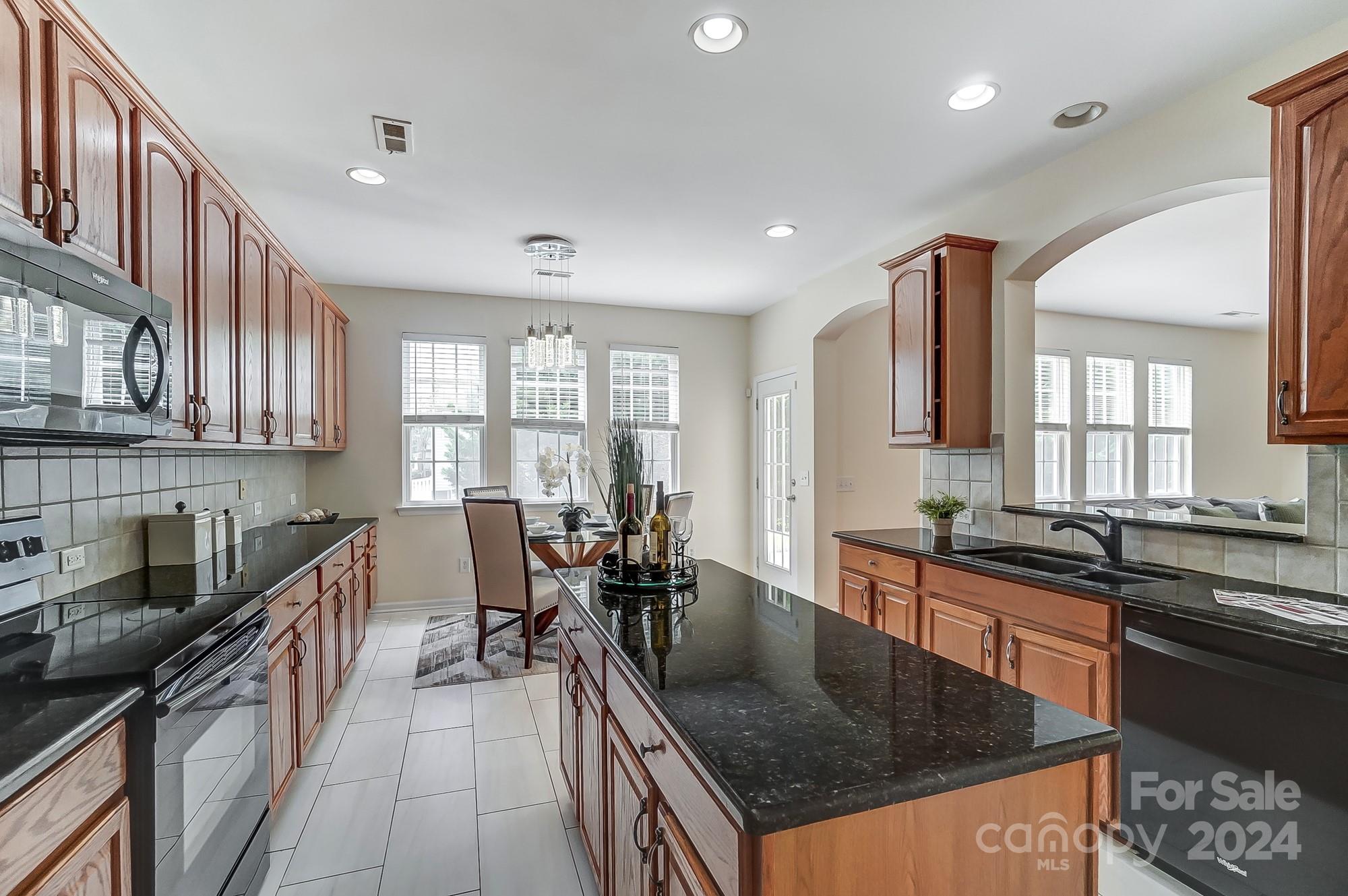 6514 Del Rio Road Charlotte, NC 28277 - Photo 11 of 42 a kitchen with stainless steel appliances granite countertop a sink a stove and a refrigerator
