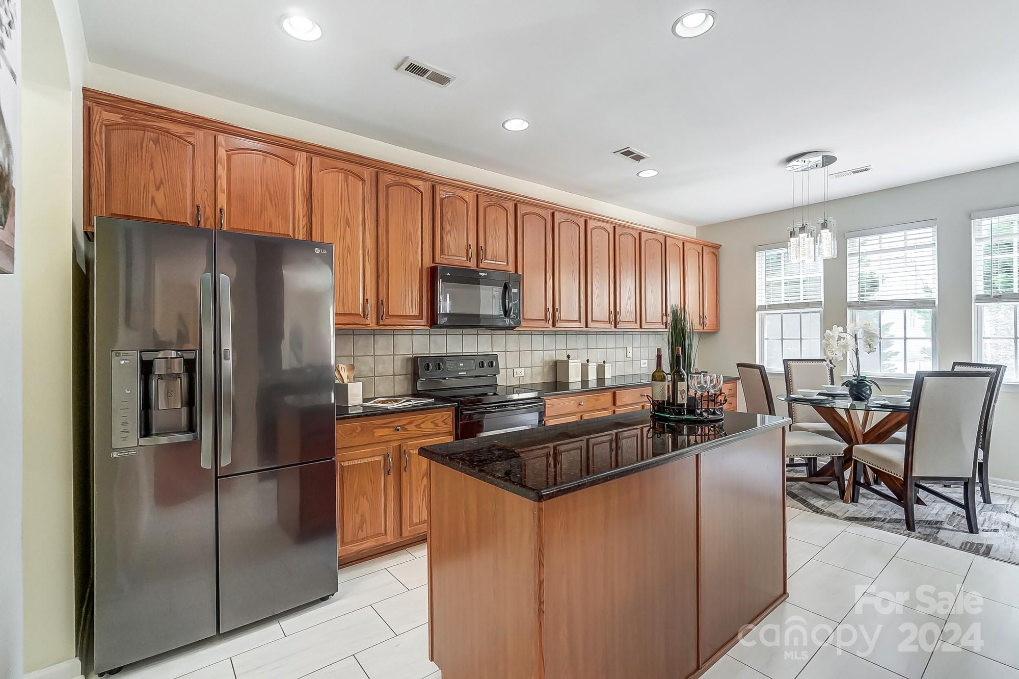 6514 Del Rio Road Charlotte, NC 28277 - Photo 12 of 42 a kitchen with stainless steel appliances granite countertop a refrigerator a stove a sink a dining table and chairs