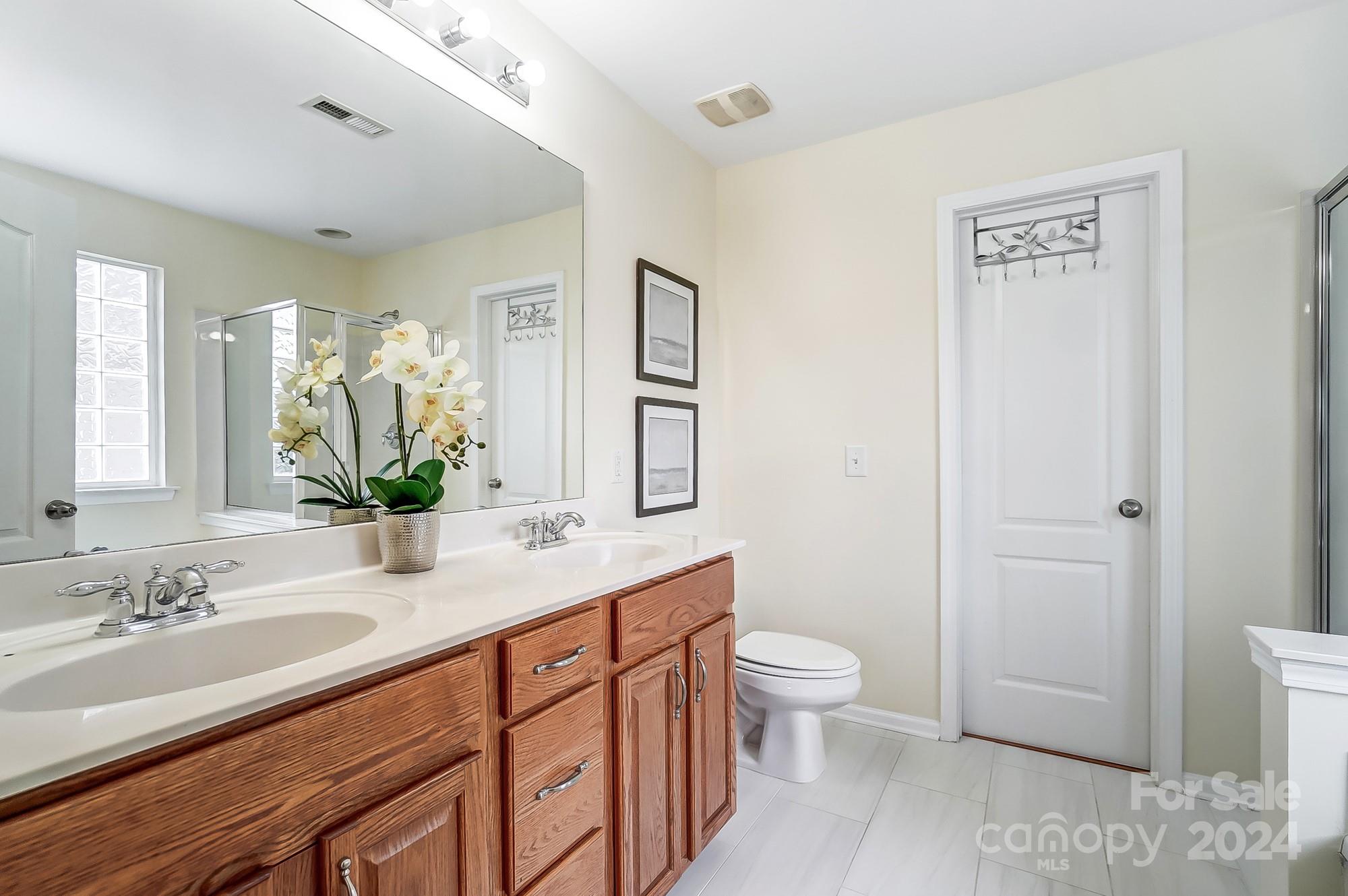 6514 Del Rio Road Charlotte, NC 28277 - Photo 24 of 42 a spacious bathroom with a granite countertop sink a toilet and a large mirror