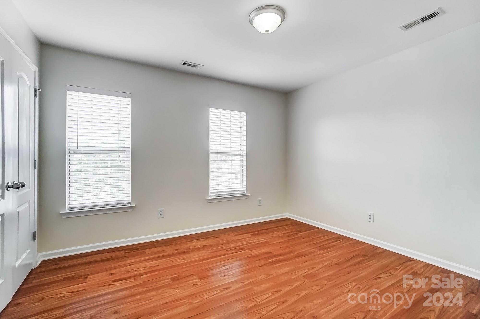 6514 Del Rio Road Charlotte, NC 28277 - Photo 37 of 42 an empty room with wooden floor and windows