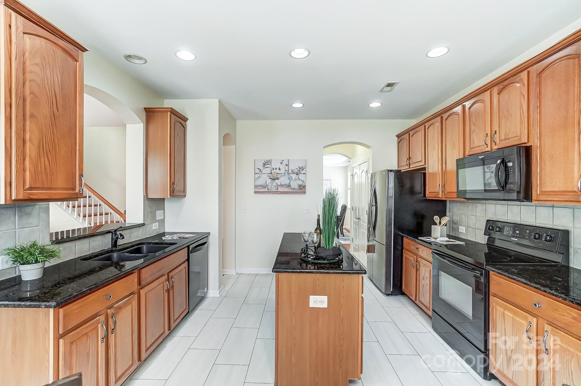 6514 Del Rio Road Charlotte, NC 28277 - Photo 9 of 42 a large kitchen with stainless steel appliances granite countertop a stove a sink and a refrigerator