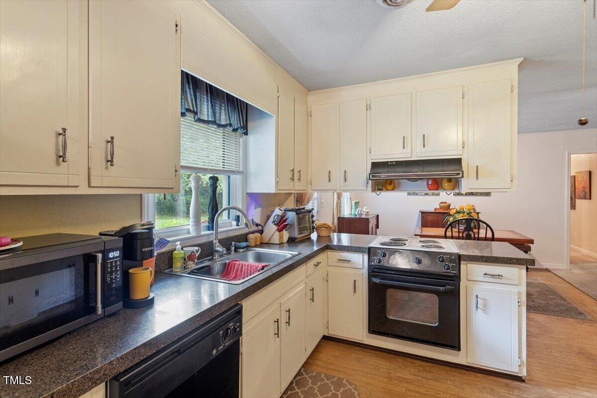 613 Devon Place Zebulon, NC 27597 - Photo 11 of 25 a kitchen with stainless steel appliances a stove a sink and cabinets