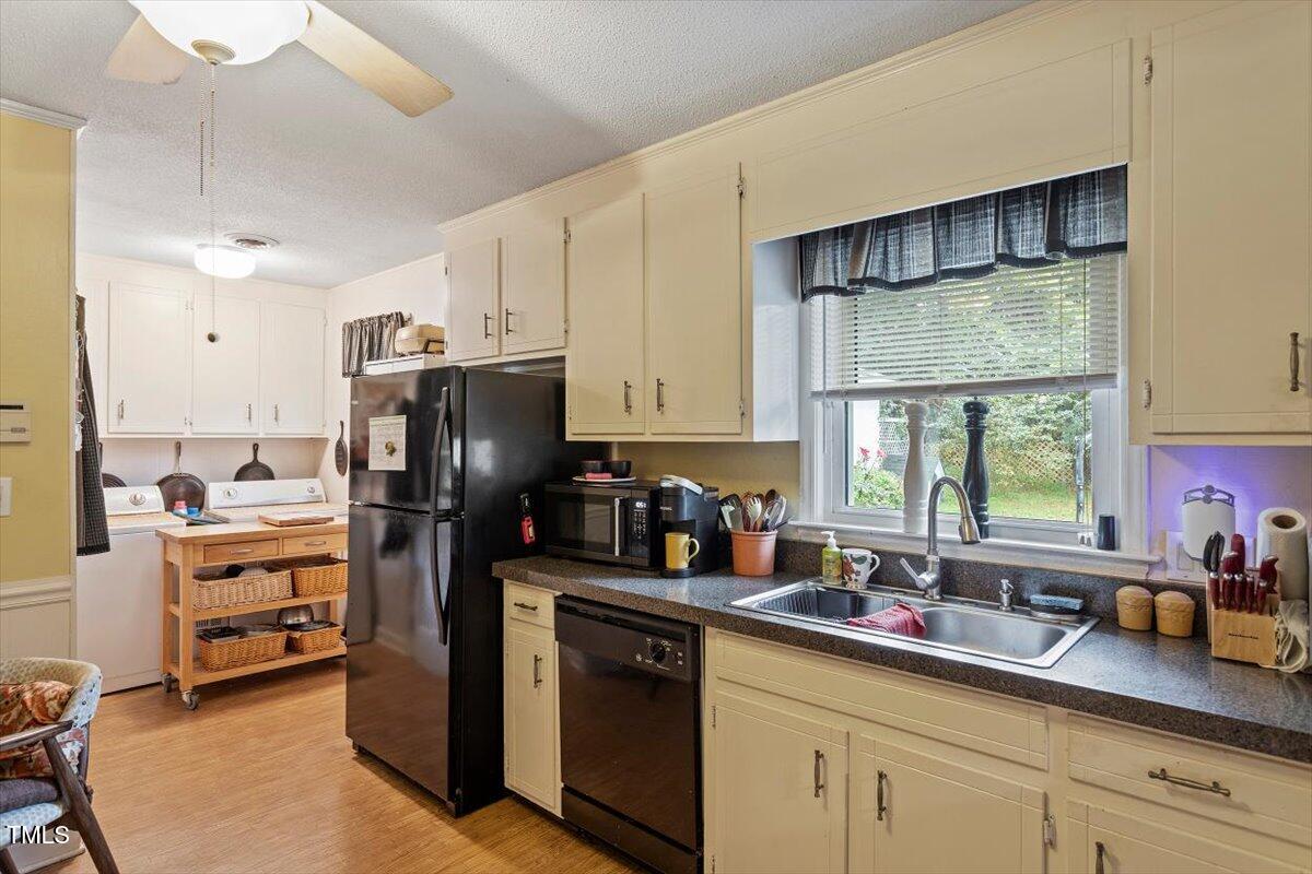 613 Devon Place Zebulon, NC 27597 - Photo 14 of 25 a kitchen with refrigerator and cabinets