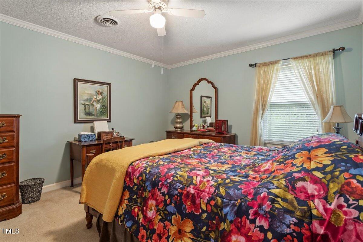 613 Devon Place Zebulon, NC 27597 - Photo 17 of 25 a bedroom with a bed and a chandelier