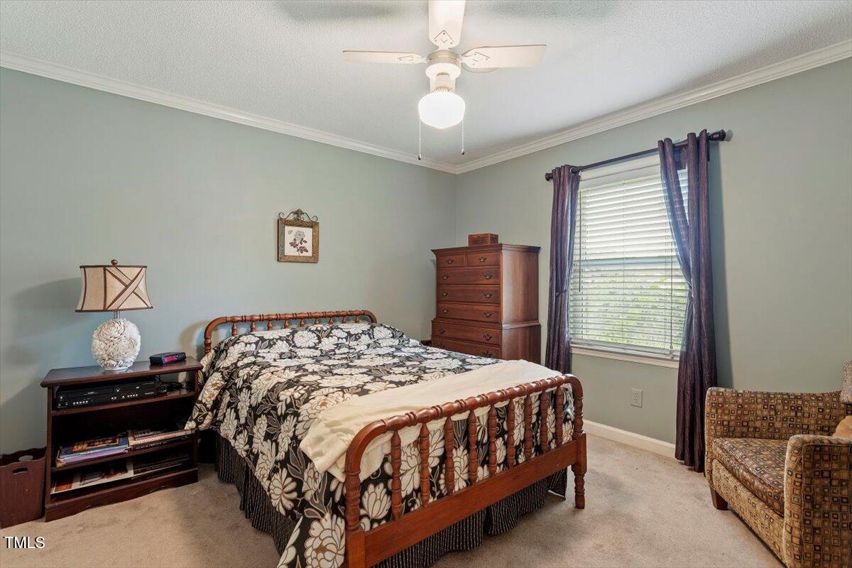 613 Devon Place Zebulon, NC 27597 - Photo 19 of 25 a bedroom with a bed and a chandelier