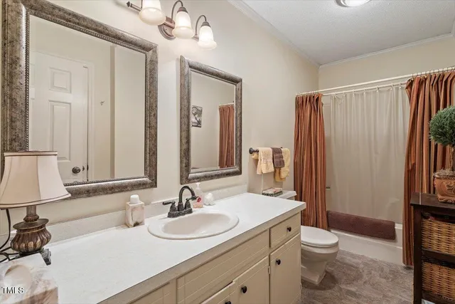 a bathroom with a double vanity sink toilet and shower