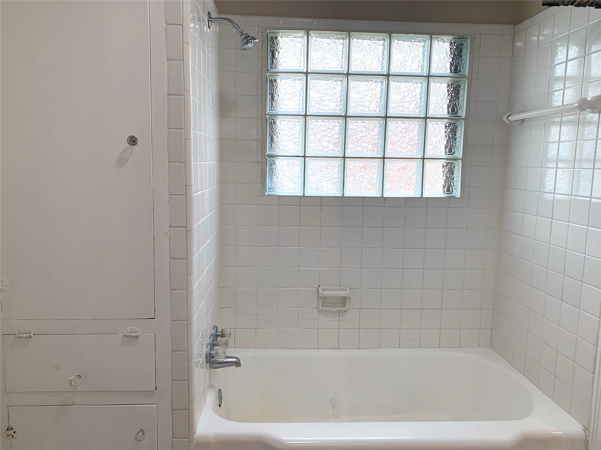 307 Avondale Street, Unit 1 Houston, TX 77006 - Photo 15 of 22 Tub with glass block for natural light. Shower in tub. Linen storage in bathroom. Neutral colors.