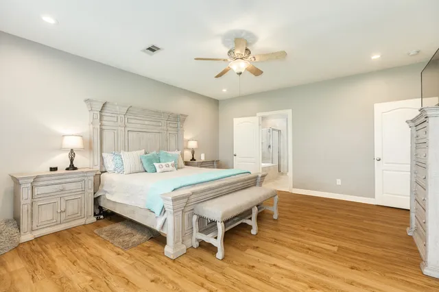 a spacious bedroom with a bed and a chandelier