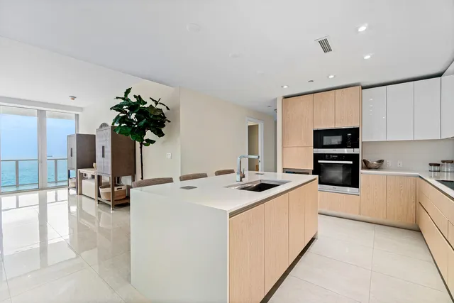 a kitchen with stainless steel appliances kitchen island a stove a sink and a refrigerator