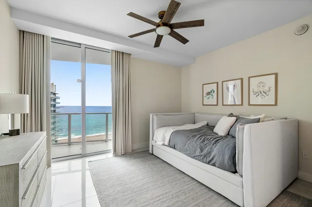 a bedroom with a large bed and a chandelier fan