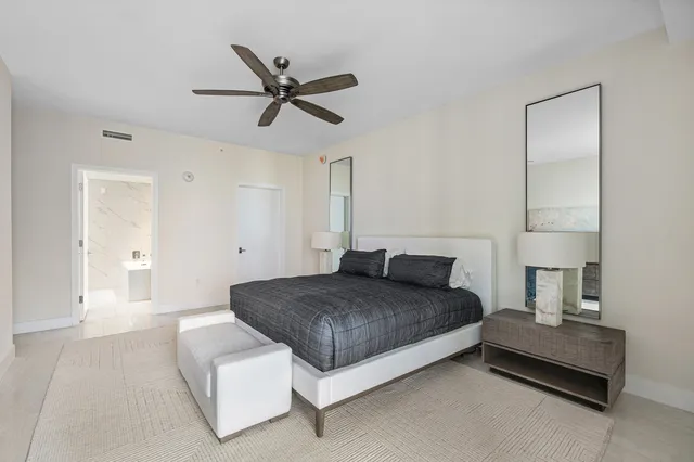 a spacious bedroom with a bed and painting on the wall