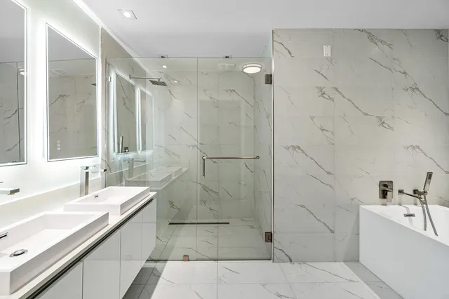 a bathroom with a tub sink shower and mirror