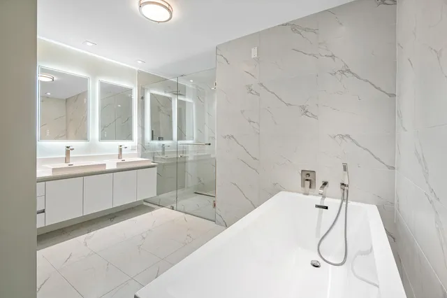 a bathroom with a double vanity sink mirror and shower