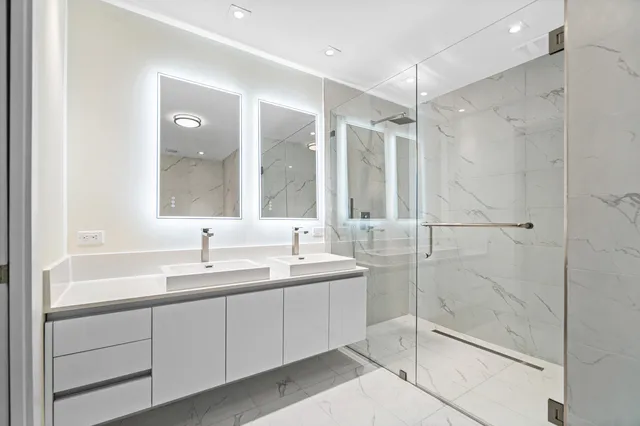 a bathroom with a double vanity sink mirror and shower