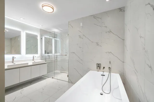 a bathroom with a double vanity sink mirror and bathtub