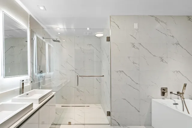 a bathroom with a granite countertop sink a toilet and shower