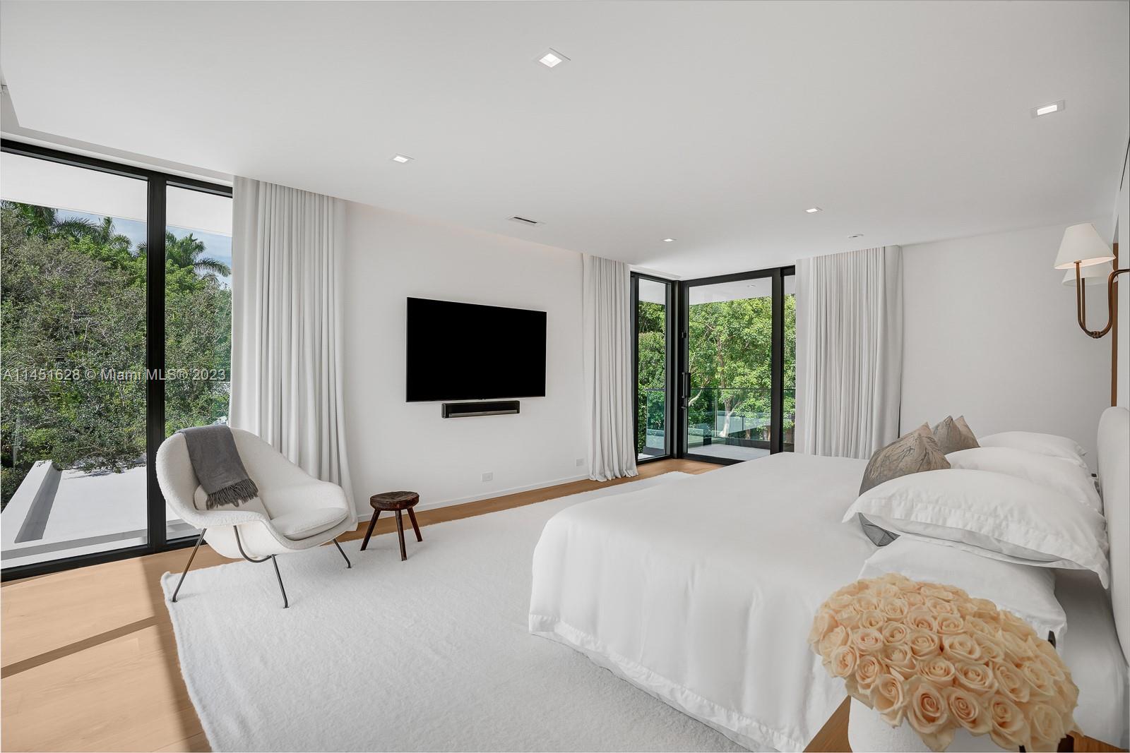 9261 School House Road Coral Gables, FL 33156 - Photo 23 of 65 a bedroom with a bed a flat screen tv and a large window