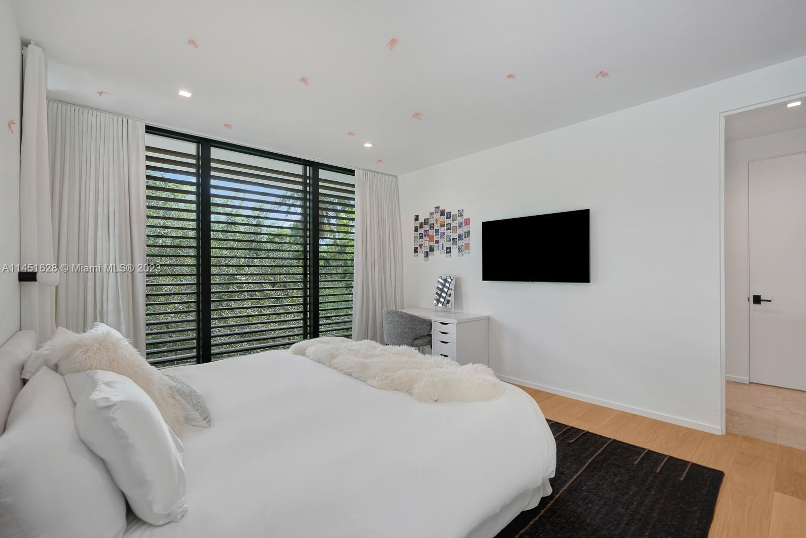 9261 School House Road Coral Gables, FL 33156 - Photo 28 of 65 a bedroom with a large bed and a flat screen tv