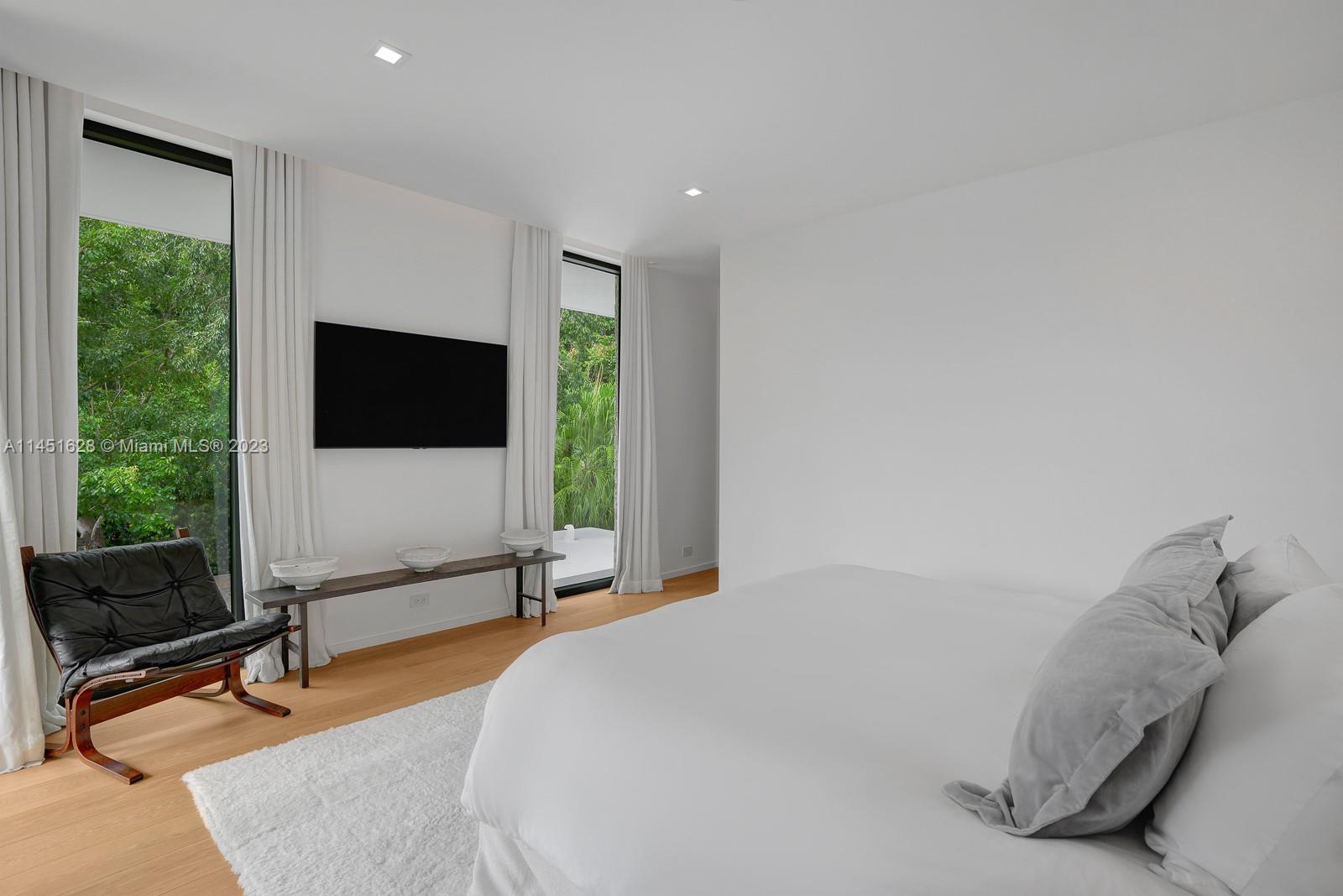 9261 School House Road Coral Gables, FL 33156 - Photo 31 of 65 a spacious bedroom with a bed and a flat screen tv