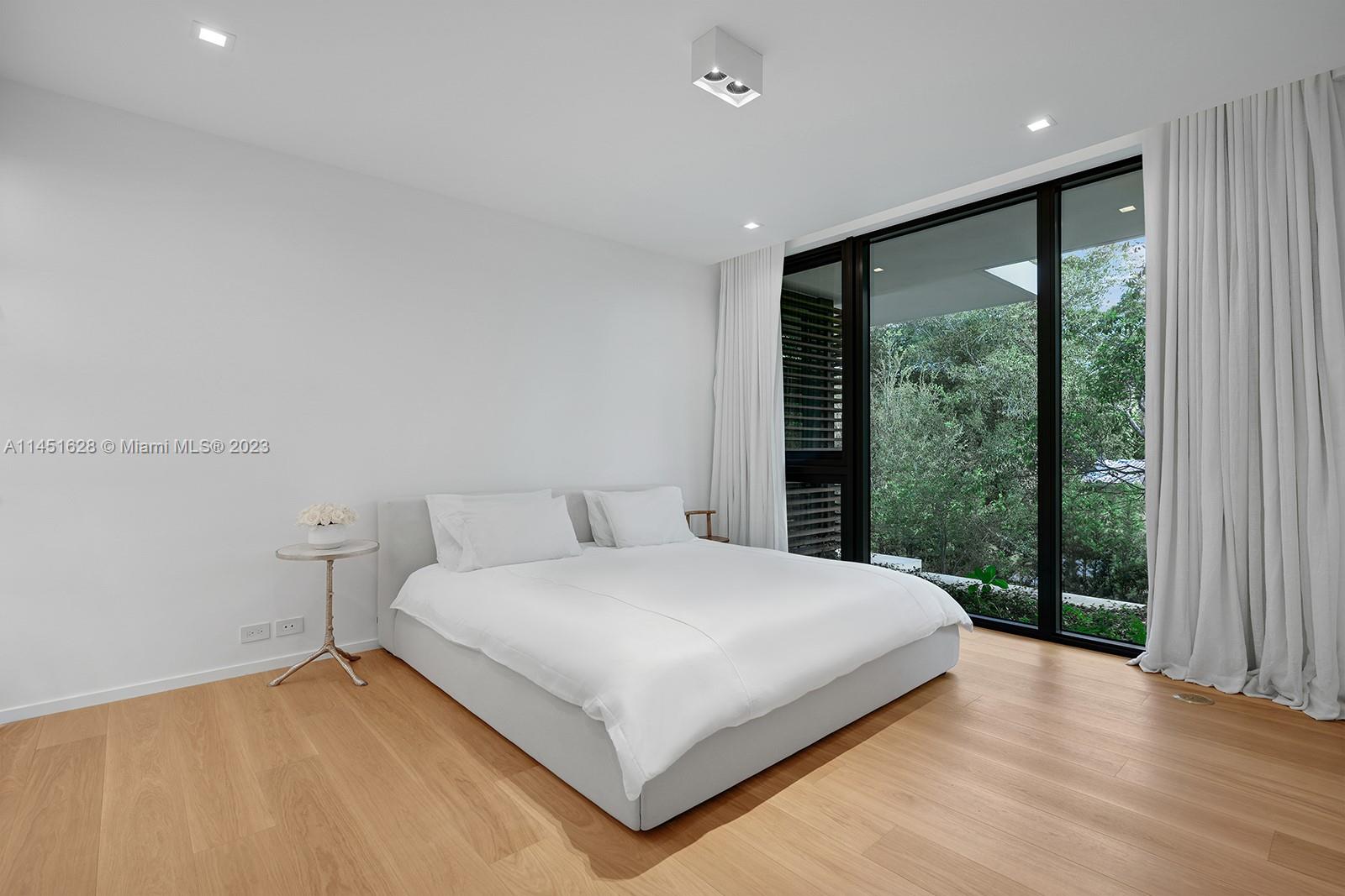 9261 School House Road Coral Gables, FL 33156 - Photo 35 of 65 a large bedroom with a large bed and wooden floor