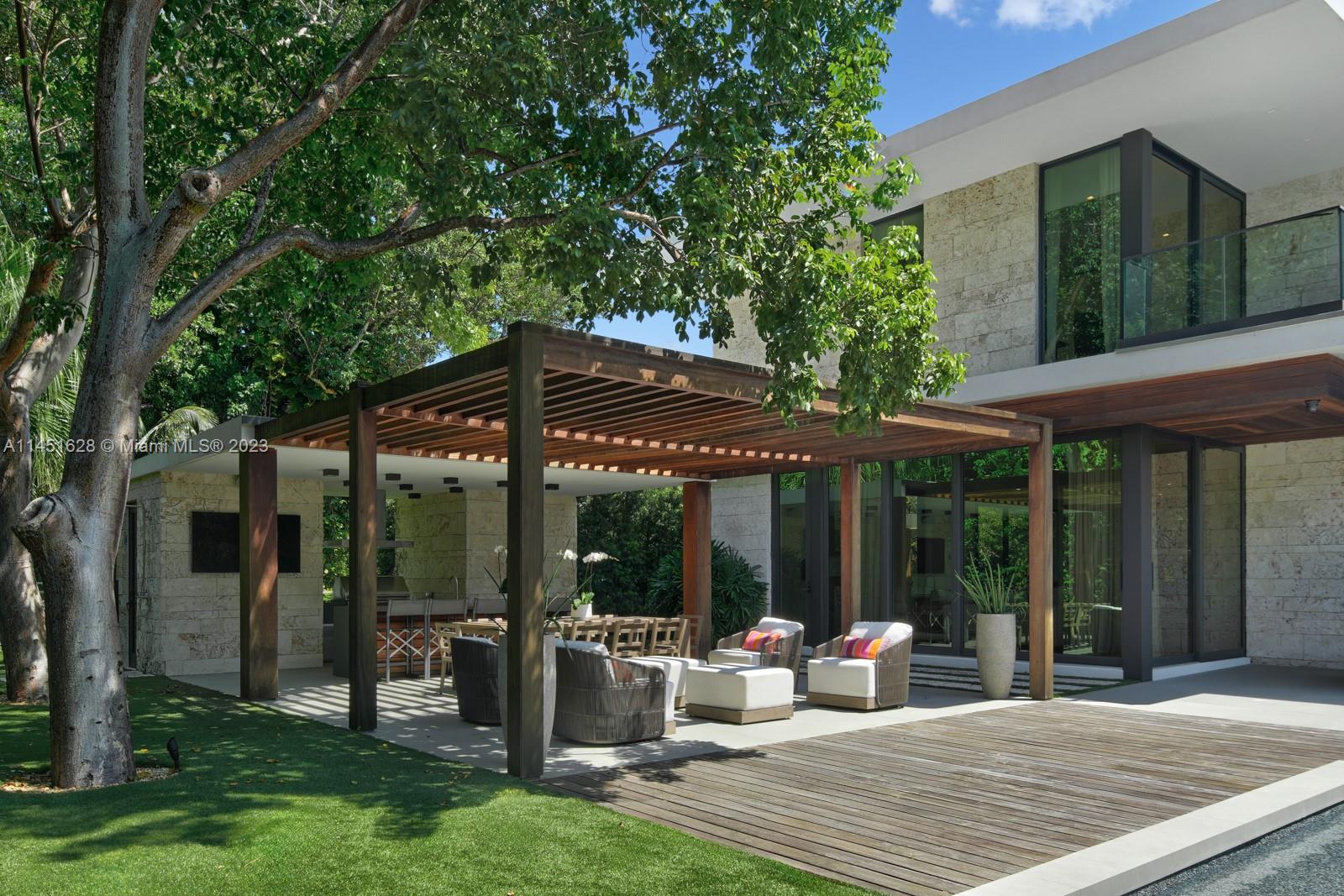 9261 School House Road Coral Gables, FL 33156 - Photo 49 of 65 a view of a patio with table and chairs potted plants and floor to ceiling window