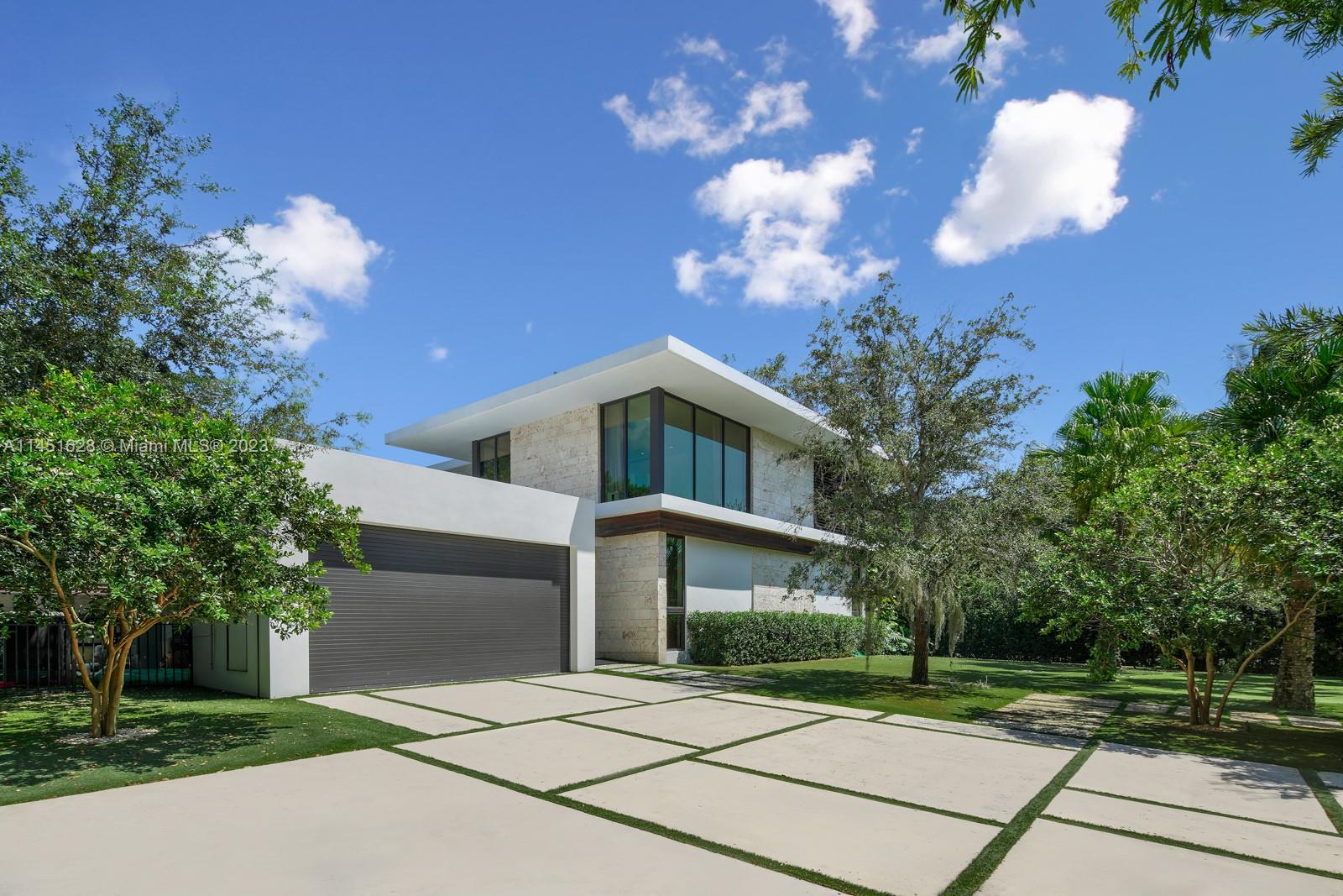 9261 School House Road Coral Gables, FL 33156 - Photo 52 of 65 a front view of a house with a yard and a garage