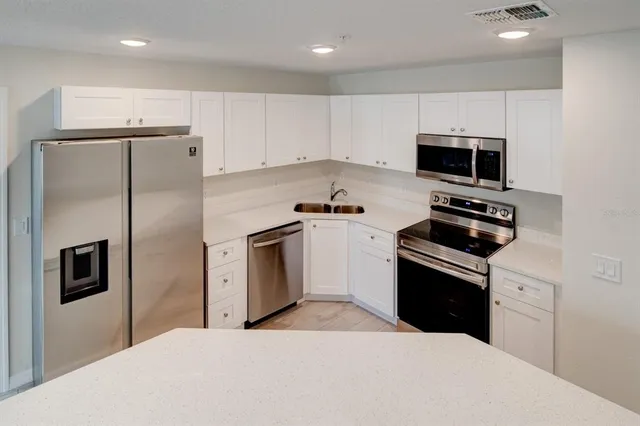 a kitchen with stainless steel appliances a refrigerator stove and microwave
