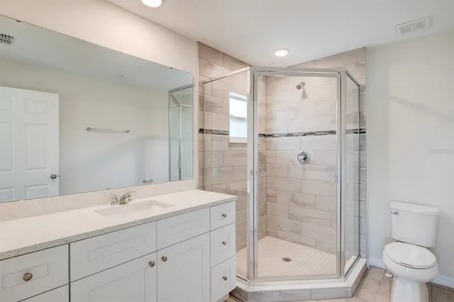 a bathroom with a shower sink vanity and toilet