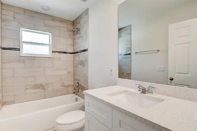 a bathroom with a bathtub shower sink vanity and toilet