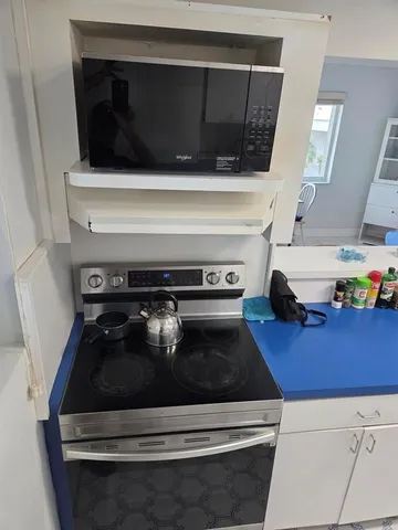 a view of living room kitchen and stainless steel appliances
