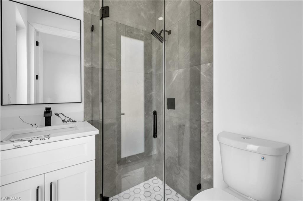 3110 23rd Street Southwest Lehigh Acres, FL 33976 - Photo 12 of 27 Bathroom with a stall shower and vanity